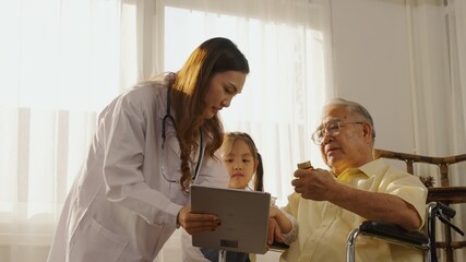 Asian elderly grandfather looks at pill bottle and listening to asian women pharmacist explaining medicine in consultation medicine at home. Senior Health, Medical, Retirement, Medicine and healthcare