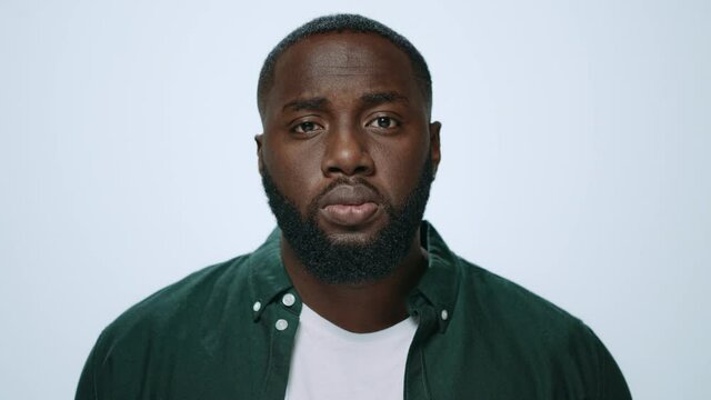 Portrait of serious african handsome raising head in grey background. 