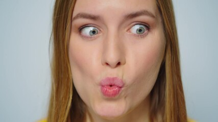 Closeup cheerful woman making funny faces on grey background in studio.