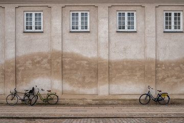Wall of a historic building, under which bicycles are parked, Copenhagen