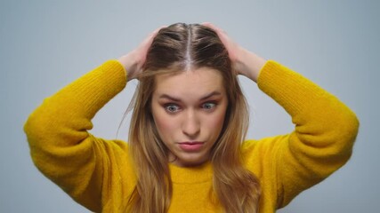 Portrait of disappointed woman feeling doubtful on grey background. Upset girl