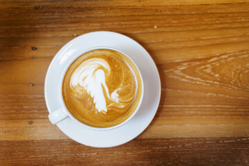 cup of coffee latte art on wooden table background with space from top view