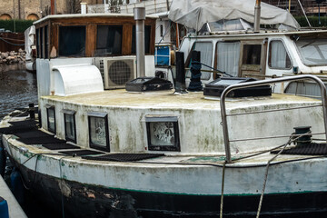 A neglected boat moored at the edge of a canal