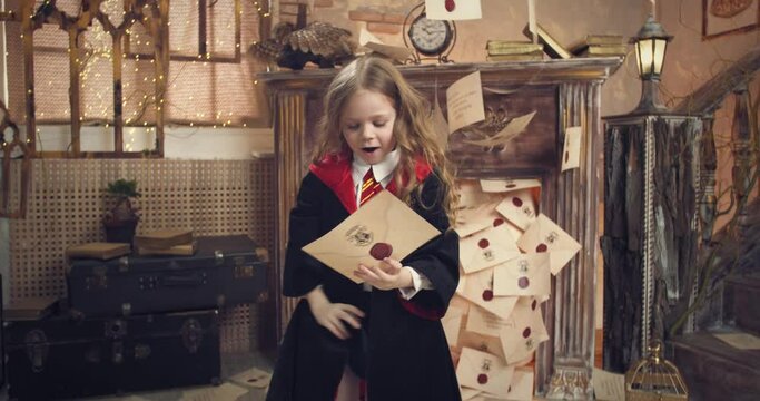 Little girl student is jumping around the letters from the wizard school, 4k