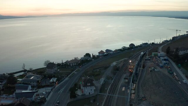 Aerial of small town under construction near large lake at sunset