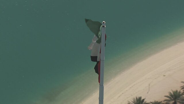 UAE flag on a background of blue water