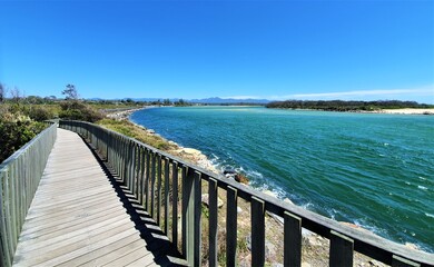 Urunga Boardwalk, sunny day, blue sky, looking out into the river mouth. 