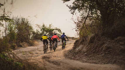 Obraz premium Group of Asian cyclists, they cycle through rural and forest roads.