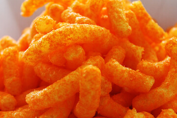 Close-up of a pile of cheesies cheese snack food.