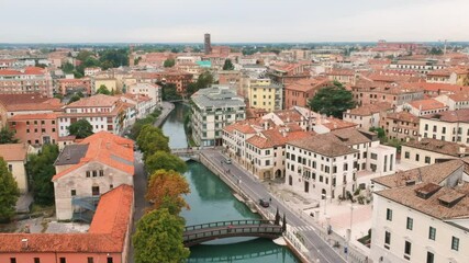AERIAL: Fly over Treviso, Italy in a summer day. Drone shot above the canals and bridges.