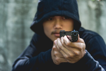 Robber assassin crime with hood points the gun already shoot