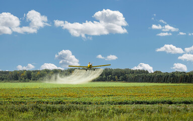 crop duster spraying a farm field pesticide. - obrazy, fototapety, plakaty