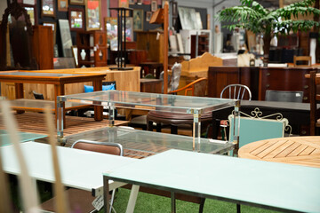 Wide selection of dining and coffee tables in modern furniture shop..