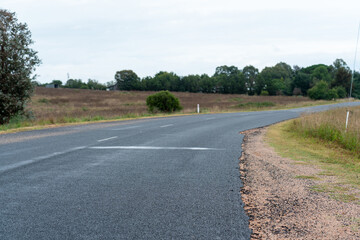Fototapeta premium road in the countryside, empty road in the country leading into the horizon with rolling hills