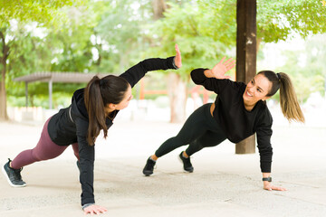 Happy workout partners exercising together outdoors