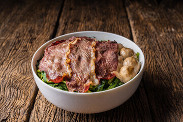 Thai style beef noodle with grilled sliced beef and beef meatball on wooden table