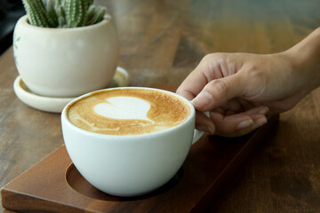 Espresso in white coffee cup with brown wooden table background