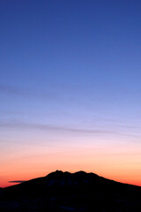 山の稜線と美しいグラデーションの夜明けの空。