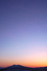 : 山の稜線と美しいグラデーションの夜明けの空。
