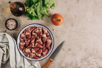 Fresh raw chicken hearts on concrete background.