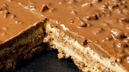 Slice of Swedish almond and chocolate cake with filling and nuts