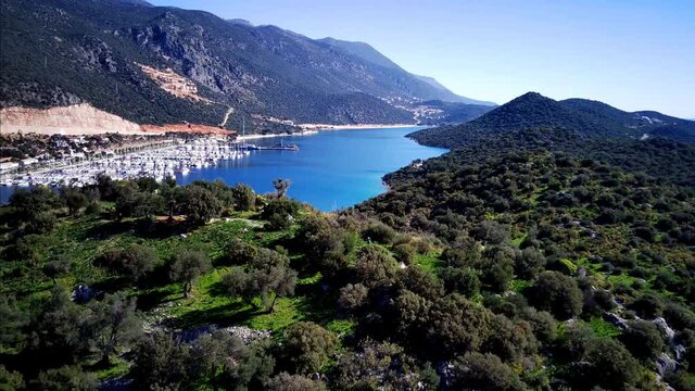 The top view from the drone of Kas resorts and city with amazing blue and clear lagoon and yachts in Mugla province of Turkey