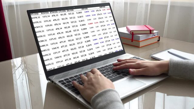 Trade in cryptocurrency at the exchange. Change of cost cryptocurrency. The girl working at home office hands on keyboard.