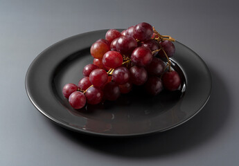 Red Globe served on a plate set against a gray background.