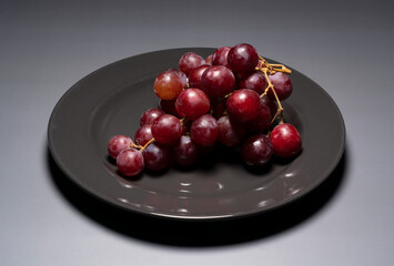 Red Globe served on a plate set against a gray background.