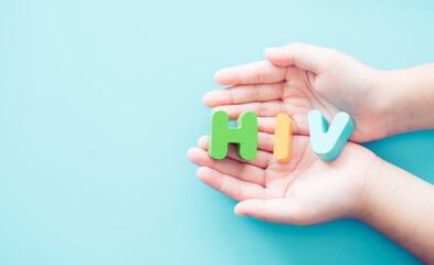 AIDs or HIV word in hand on blue background, fight against HIV, AIDS. World Aids Day Awareness.Healthcare and medical. Charity, support, donation, give, encourage patient, Hope, Aids in child kid.