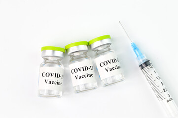 Syringe and Covid-19 bottle vaccination over white background.