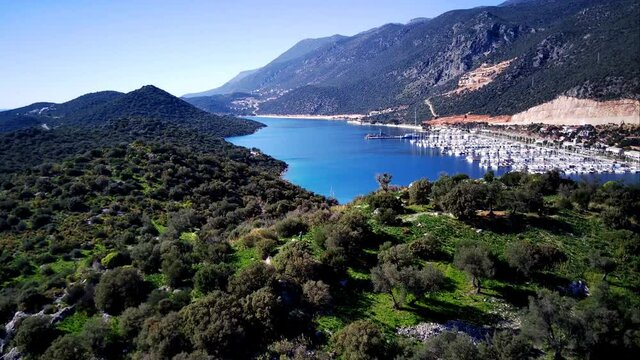 The top view from the drone of Kas resorts and city with amazing blue and clear lagoon and yachts in Mugla province of Turkey