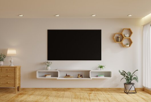 TV in the living room on a white wall by the window, decorated with plants, vases, flowers, toys and lamps.3d rendering.