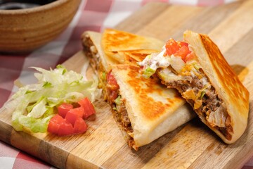 A close up photo of a homemade crunch wrap taco on a cutting board.