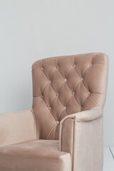 a classic pink armchair sits in a white room on a wooden floor. copy space