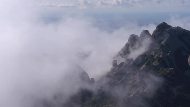 Scenic aerial drone view of Montserrat mountain landscape, covered by mist cloud