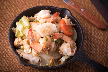 Chicken fried noodles in a black pan