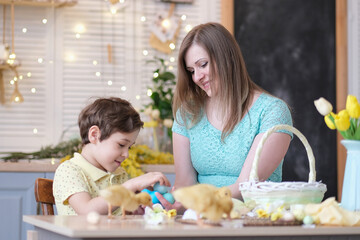 Obraz na płótnie Canvas Mother and son having fun together and celebrating feast. family getting ready for easter. Little and mom decorating home. soft focus
