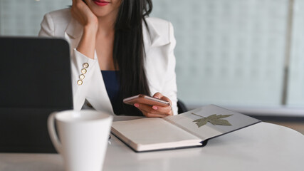 Cropped shot of executives businesswoman using smart phone at her workplace.