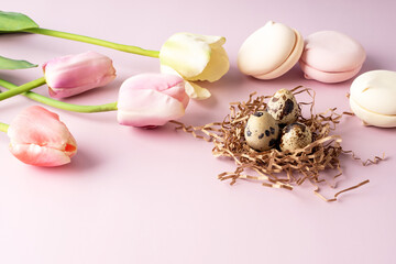 Greeting Easter background. Flowers, tulips, eggs, sweets on a pink background. Happy Easter
