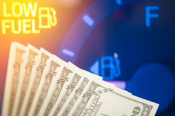 Dollar bills against oil mileage dashboard background