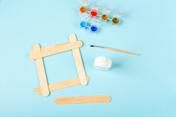 DIY and kid's creativity. Step by step instruction: how to make photo frame of ice cream sticks. Step2 glue sticks together. Children craft for Fathers Day.