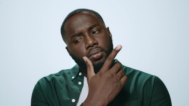 Portrait of pensive african american guy thinking on grey background.