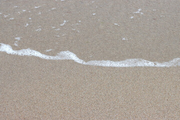 Coastline, wave on the beach sand.