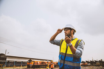 Caucasian man railway engineer use walkie-talkie talking in the site work of train garage.