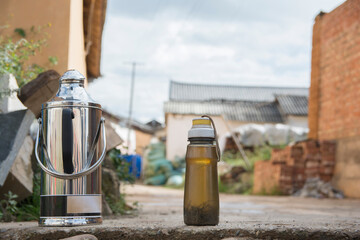 Plastic teapot and kettle, with Chinese herbal tea, outdoors. Shaxizhen, Jianchuan County, Dali,...
