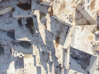 Terraces of cut stone material at marble quarry. Marble quarry sledges top down aerial view