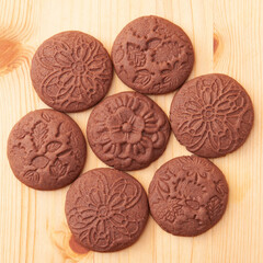 Round chocolate cookies with patterns on wooden table