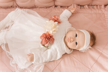 Portrait of a cute 6-month-old baby, a newborn girl lying in a baby crib