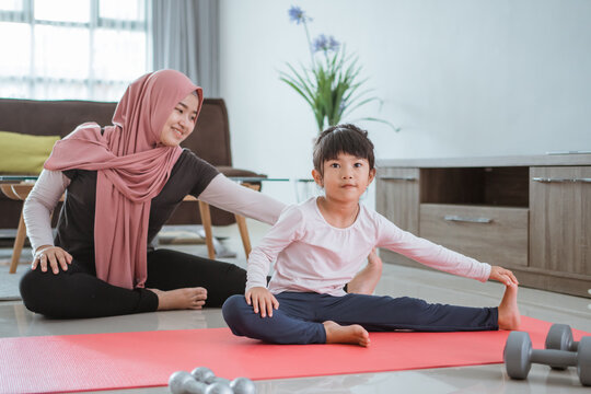 Beautiful Muslim Mother And Daughter Workout Together To Get Healthy. Family Woman And Child Enjoy Exercising At Home